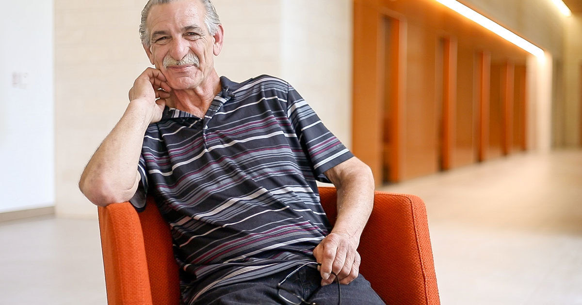 A clinician at UT Health Austin's Comprehensive Memory Center smiles while pointing to a page in a memory book.